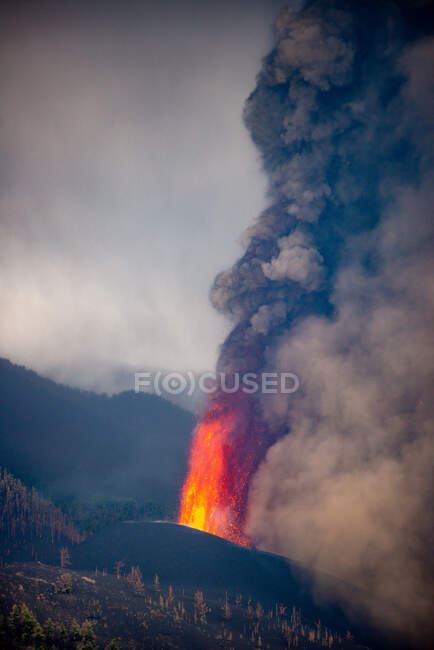 Lave chaude et magma coulant du cratère avec des panaches noirs de fumée. Éruption volcanique Cumbre Vieja à La Palma Îles Canaries, Espagne, 2021 — Photo de stock