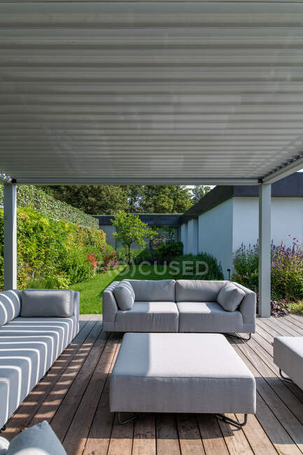 Yard of modern house with cozy lounge zone with comfortable sofas on sunny day — Stock Photo