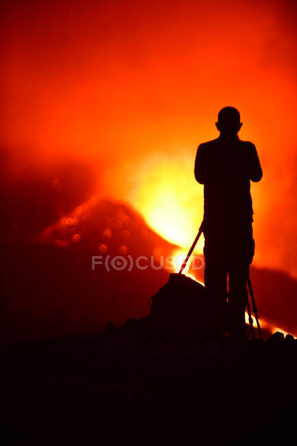 Visão traseira da silhueta de um homem gravando e fotografando com um tripé a explosão de lava em La Palma Ilhas Canárias 2021 — Fotografia de Stock