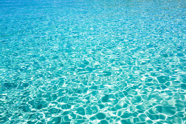 Abstrakter Hintergrund glühender Meeresaqua mit blauen Wellen an einem sonnigen Tag auf Ibiza Spanien — Stockfoto