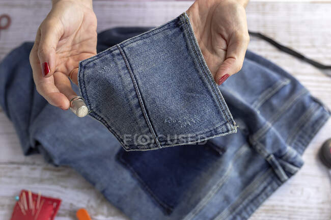De cima da colheita fêmea irreconhecível com o bolso de fixação de manicura de calça na mesa no quarto leve — Fotografia de Stock