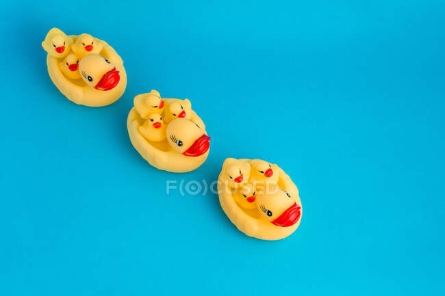 De dessus ensemble de canetons en caoutchouc mignons et canard maman jouets placés sur fond bleu vif — Photo de stock