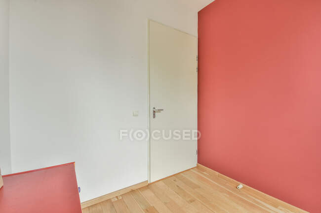 Moderne Raumausstattung mit Tür zwischen kontrastierenden Wänden in Leuchtturm mit Holzboden — Stockfoto