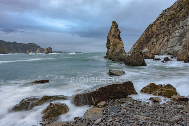 Spektakuläre Szenerie mit schäumenden Meereswellen, die raue Felsformationen in verschiedenen Formen am Silence Beach in Asturien spülen — Stockfoto