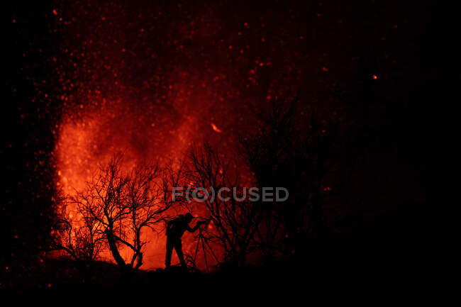 Silhouette d'un photographe contre l'explosion de lave et de magma sortant du cratère. Éruption volcanique Cumbre Vieja à La Palma Îles Canaries, Espagne, 2021 — Photo de stock