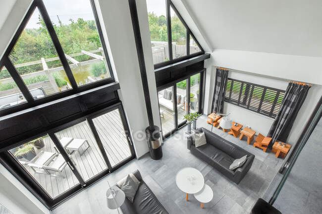 Von oben Sofas in der Nähe von Kamin mit Rohr im geräumigen Wohnzimmer mit Panoramafenstern — Stockfoto