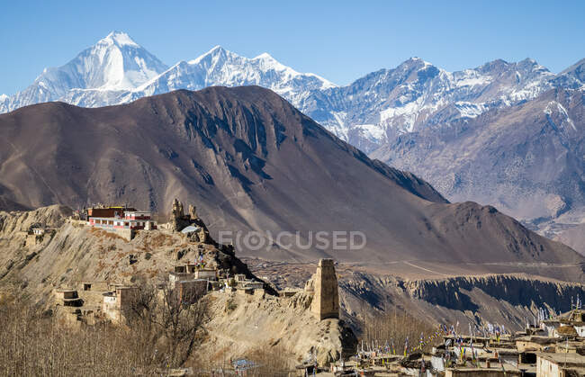 Stone residential houses in Muktinath village on rocky hills surrounded by high Annapurna Circuit mountain range in Nepal — Stock Photo