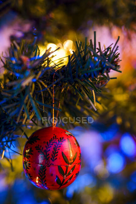 Adorno festivo colgado en la rama de árbol de coníferas decorado con guirnalda para la celebración de Navidad - foto de stock