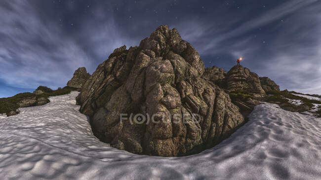 Vue panoramique du touriste avec torche sur monture sèche au milieu du sable sous un ciel nuageux la nuit — Photo de stock