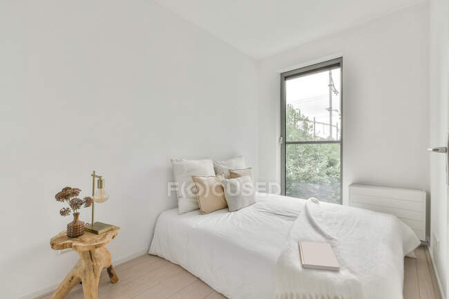 Innenraum eines geräumigen hellen Schlafzimmers mit bequemem Bett und großen Fenstern in einer modernen Wohnung tagsüber — Stockfoto