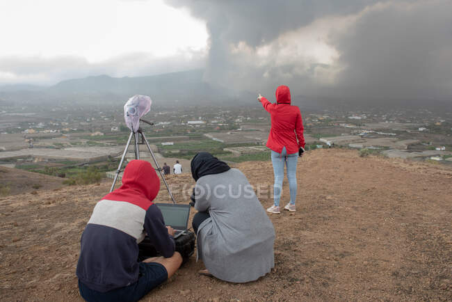 Back view of volcanologists with technical equipment observing the Cumbre Vieja volcanic eruption in La Palma Canary Islands, Spain, 2021 — Stock Photo