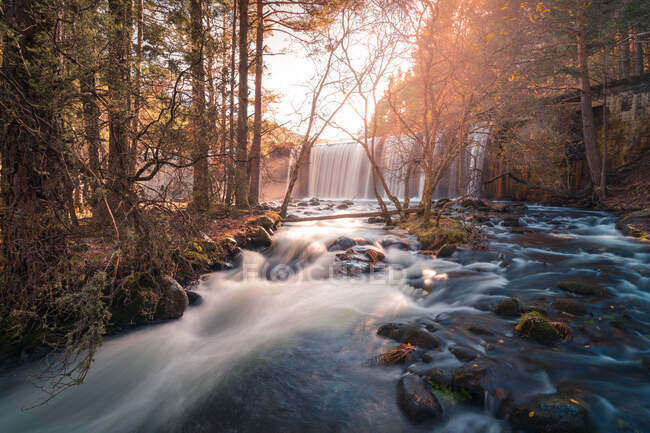 Cenário pitoresco de cachoeira e rio com pedras que fluem através da floresta de outono na Serra de Guadarrama, na Espanha, em dia ensolarado — Fotografia de Stock