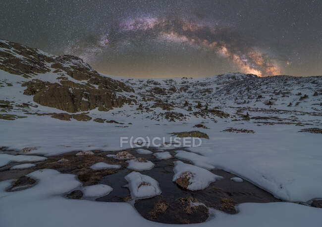 Paesaggio di pozzanghera di acqua ghiacciata vicino alla montagna sotto il cielo stellato notturno con Via Lattea — Foto stock