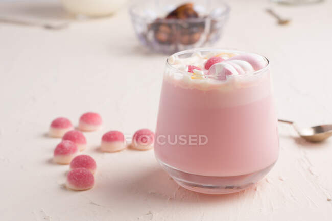 Copa de chocolate blanco caliente dulce con caramelos de jalea rosa y malvavisco servido en mesa blanca — Stock Photo