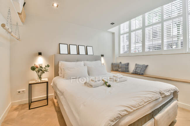 Interior do quarto contemporâneo com cama e lâmpadas brilhantes contra a parede no hotel — Fotografia de Stock