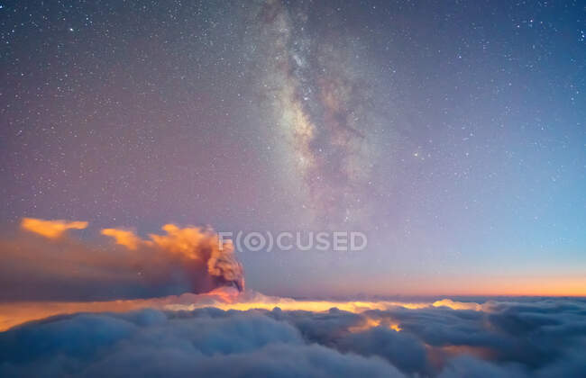 Vertical milky way and volcano smoke over a sea of bluish clouds on a starry night. Cumbre Vieja volcanic eruption in La Palma Canary Islands, Spain, 2021 — Stock Photo