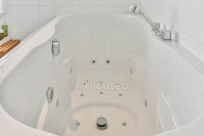 Kreatives Design der Badewanne mit Edelstahlhahn und Hydromassagesystem im Leuchtturm — Stockfoto