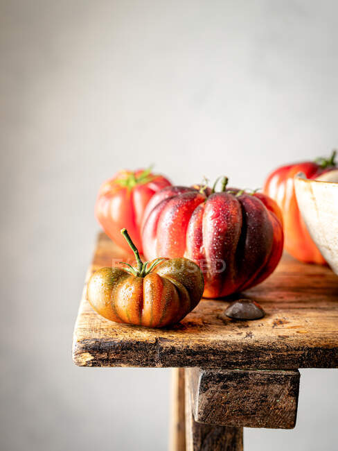 Fechar de vários tomates vermelhos em uma mesa de madeira — Fotografia de Stock