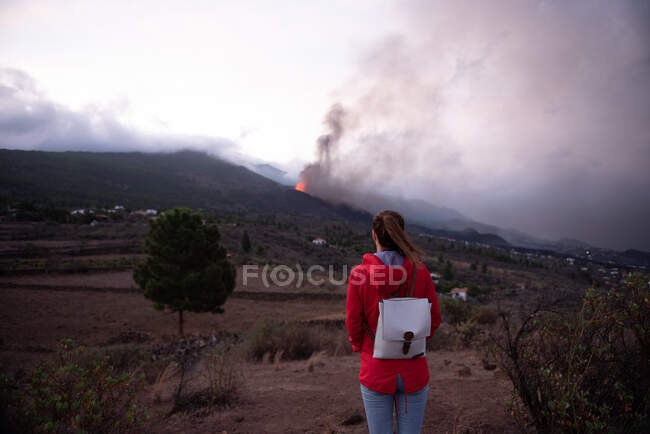 Vue arrière d'une femme anonyme observant le volcan en éruption de Cumbre Vieja dans les îles Canaries de La Palma 2021 — Photo de stock