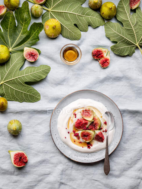 Placa de vista superior de iogurte com figos em uma mesa — Fotografia de Stock