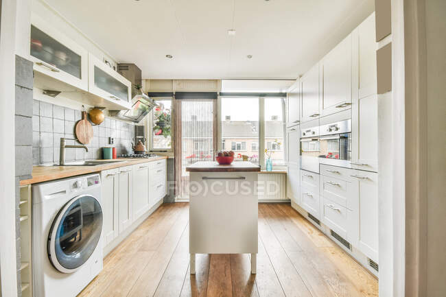 Interior of spacious kitchen with contemporary appliances and white furniture in flat designed in minimal style — Stock Photo