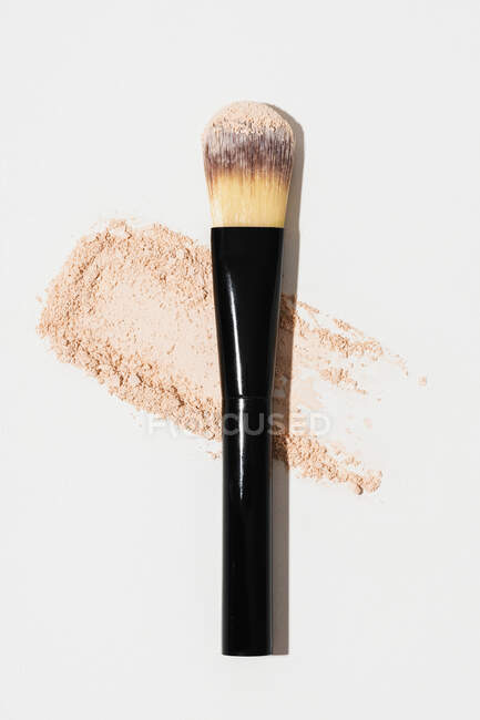 Brosse cosmétique compacte pour le visage et le maquillage placée sur fond blanc — Photo de stock