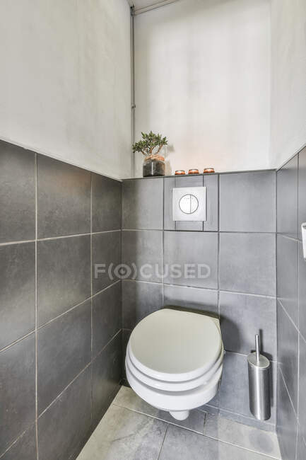 Интерьер современного туалета минималистского стиля с чистым туалетом, установленным на черепичной стене — стоковое фото