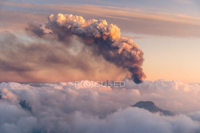Mar de nuvens de cima e no fundo uma fumaça preta produzida por um vulcão. Erupção vulcânica Cumbre Vieja nas Ilhas Canárias de La Palma, Espanha, 2021 — Fotografia de Stock