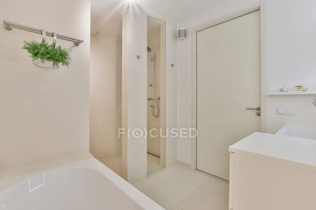 Design créatif de salle de bain avec baignoire contre armoire et lavabo à la maison — Photo de stock