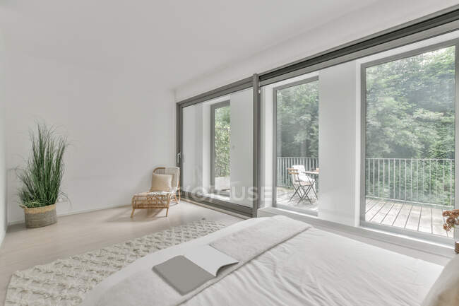 Interior do quarto leve com cama confortável com almofadas coloridas e janela aberta à luz do dia — Fotografia de Stock