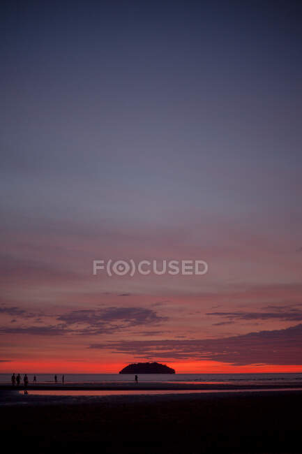 Vista panorâmica do mar sem fim com turistas passeando na costa arenosa ao pôr do sol na Malásia — Fotografia de Stock