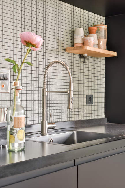 Detail of interior design of modern kitchen with faucet and sink installed into counter in stylish apartment — Stock Photo