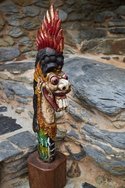 Традиционная балийская скульптура дракона с орнаментом у грубой стены в дневное время на Бали Индонезия — стоковое фото