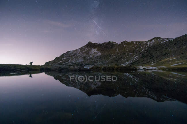 Paesaggio pittoresco di fiume calmo contro le montagne in Sierra de Guadarrama in Spagna sotto il cielo stellato in tempo di sera — Foto stock