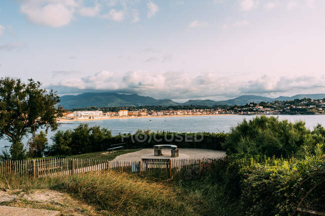 Scenery view of bench against ocean and ridges under cumulus clouds in Saint Jean de Luz France — Stock Photo