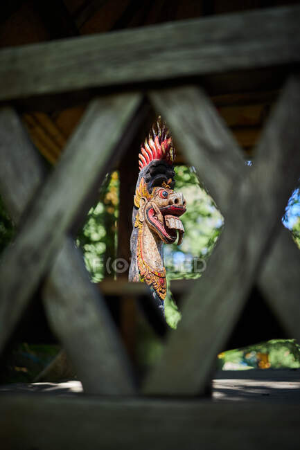 Escultura de dragón con adorno sobre pedestal en construcción envejecida de bambú en Bali Indonesia - foto de stock