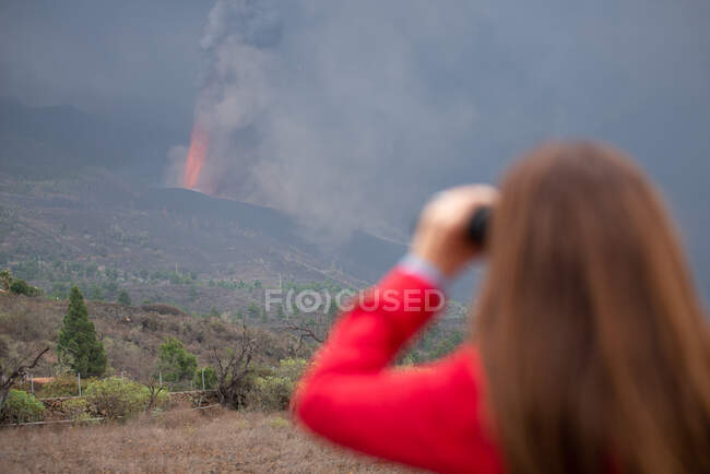 Анонимная женщина, наблюдающая извержение вулкана Кумбре-Вьеха на Канарских островах Ла-Пальма 2021 — стоковое фото