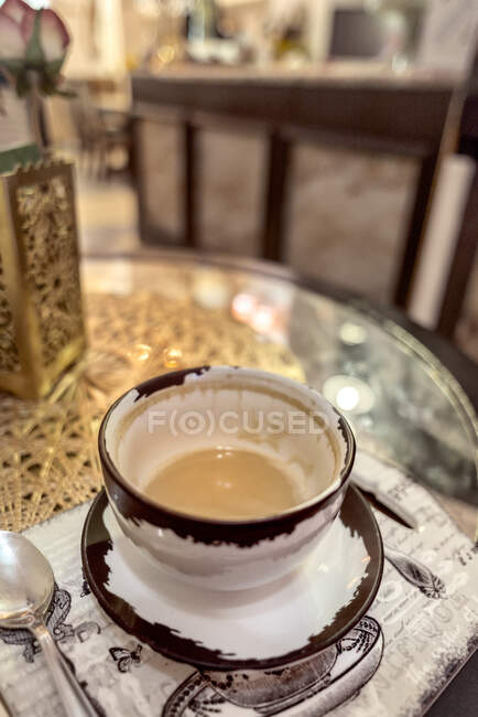 Taza de cerámica de café aromático en la mesa con servilletas en la cafetería - foto de stock