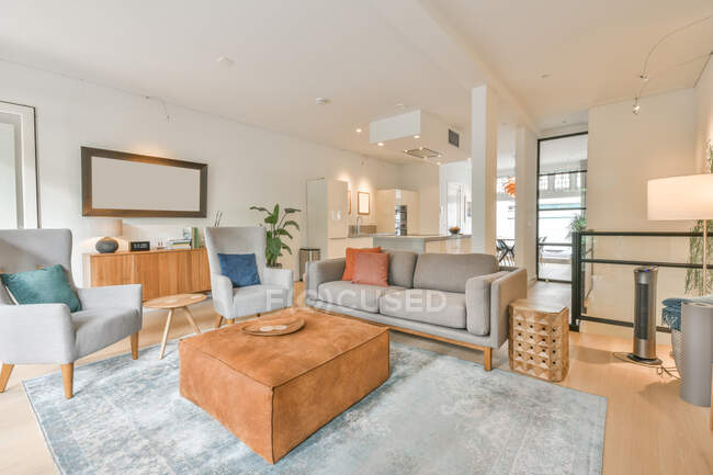 Interieur des modernen Wohnzimmers mit bequemen Sofas und Sesseln mit Kissen im Ferienhaus — Stockfoto
