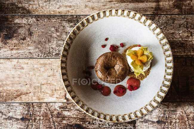 Dall'alto deliziosi muffin e muffin appena sfornati con yogurt e salsa di frutta posti sul tavolo di legno alla luce del giorno — Foto stock