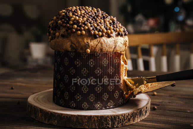 Crop unrecognizable female with knife chopping traditional Italian panettone prepared for dinner for celebrating Christmas — Stock Photo