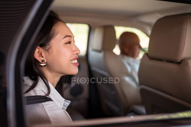 Side view of Asian female passenger sitting in car — Stock Photo
