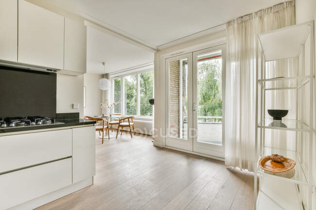 Einfache weiße Schränke mit Geräten in der hellen modernen Küche der neuen Wohnung — Stockfoto