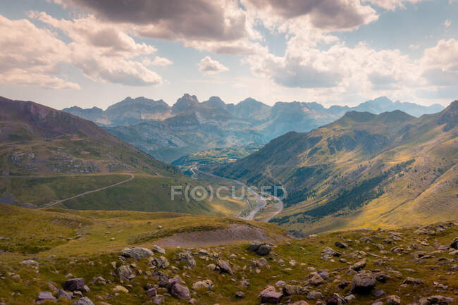 Vallée verte avec des collines herbeuses situées contre des montagnes rocheuses rugueuses et ciel nuageux dans la nature sauvage de l'Espagne le jour de l'été — Photo de stock