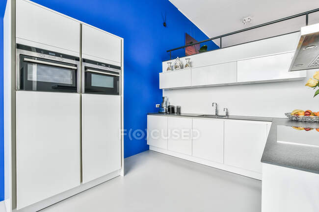 Creative design of kitchen against refrigerator and cabinet in light house — Stock Photo