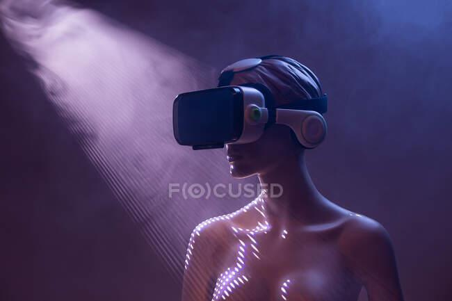 Frauenattrappe mit VR-Brille vor leuchtend violettem Hintergrund als Symbol futuristischer Technologie — Stockfoto