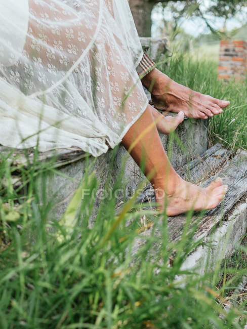 Side view of the bare feet of an anonymous heterosexual couple perched on an old staircase. — Stock Photo