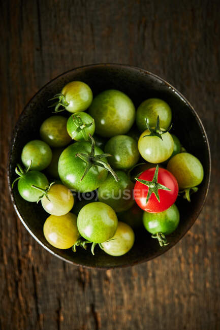 From above of whole green and red cherry tomatoes in bowl collected in farm during harvest season — Stock Photo