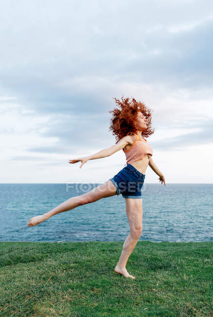 Corps complet de femmes pieds nus dansant sur la côte de la mer ondulante — Photo de stock