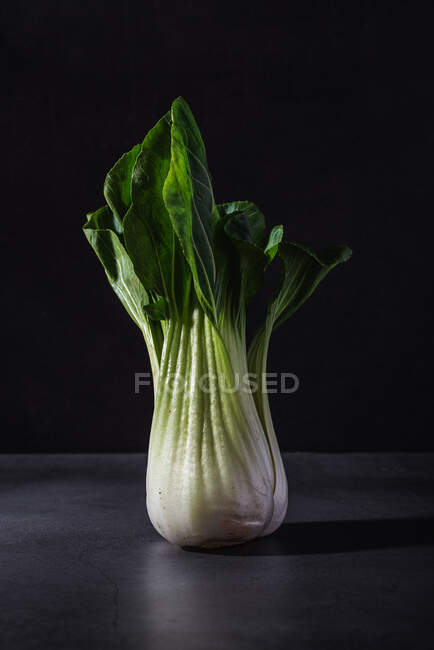 Healthy fresh bok choy cabbage leaf vegetable placed on black table against dark background — Stock Photo